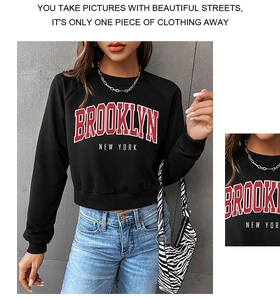 Close-up of red Brooklyn New York letter print on black cropped crewneck sweatshirt
