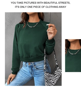 Detail view of dark green cropped crewneck sweatshirt with ribbed cuffs and hem textures