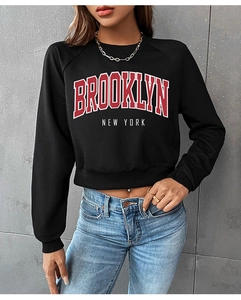 Detail of Brooklyn New York letter print on black long sleeve cropped sweatshirt