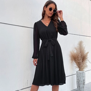Elegante abito midi a pieghe nero con scollo a V e cintura in vita in ambiente esterno