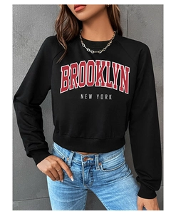 Detail of Brooklyn New York letter print on black cropped sweatshirt with ribbed hem