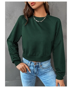 Detail of a dark green cropped sweatshirt featuring ribbed cuffs and soft fabric texture