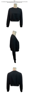 Three-way view of a black long-sleeved cropped sweatshirt with ribbed cuffs and hemline