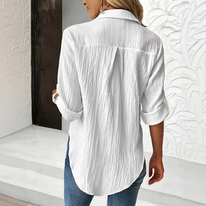 Minimalist white long-sleeved shirt with textured fabric and curved hem for women