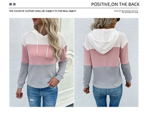 Macro detail of tricolor waffle knit hoodie showing pink white and grey color blocking