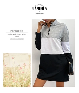 Detail view of women's half-zip dress with grey white and black patchwork design