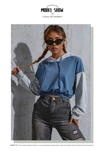 Detalle de sudadera corta bicolor con capucha y cintura elástica para mujer en azul