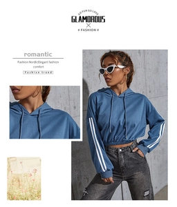 Detail of smog blue cropped hoodie featuring white stripes on sleeves and elastic waist hem
