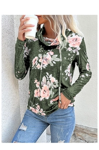 Dettaglio del top a collo alto verde muschio con stampa floreale rosa e trama morbida