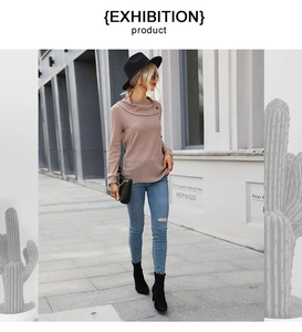 Outdoor street style view of woman in pink knit sweater with cowl neck and ripped blue jeans