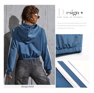 Detail of blue cropped hoodie featuring double sleeve stripes and elastic hem design