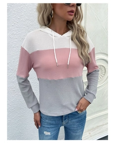 Detailed view of women's waffle knit hoodie featuring white, pink, and grey color-blocking