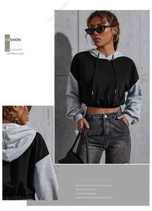 Detalle de sudadera corta bicolor con capucha ajustable y dobladillo elástico mujer