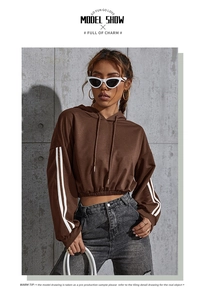 Detail of a brown cropped hoodie with white stripes on sleeves and casual denim style