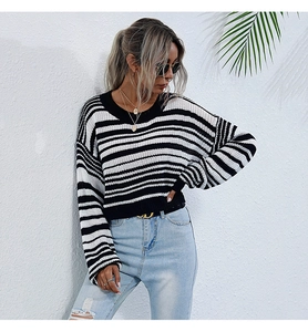 Gros plan du pull en maille rayé noir et blanc avec col rond et coupe courte moderne