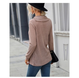 Macro detail of pink ribbed knit sweater with slouchy turtle neck and textured fabric