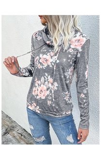 Dettaglio della felpa a dolcevita floreale con coulisse e jeans in denim strappati abbinati