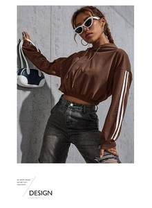 Detail view of brown cropped hoodie with white athletic stripes and elastic waist hem