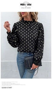 Detail of black chiffon blouse with gold diamond pattern, smocked cuffs and ruffled collar