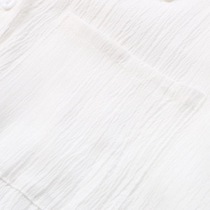 Close-up of seersucker fabric texture and square pocket on a white long sleeve shirt