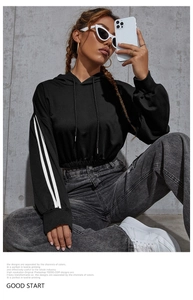 Detail view of black cropped hoodie with white side stripes and ribbed cuffs on sleeve