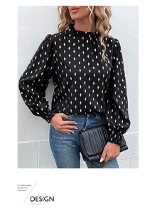 Detail of elegant black long sleeve blouse with golden diamond print and ruffle collar