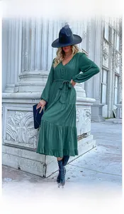 Detail view of dark green V-neck dress with adjustable waist tie and tiered skirt hem