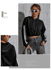 Detail of cropped black hoodie featuring white sleeve stripes and drawstring hood