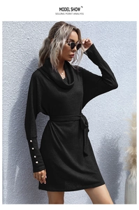 Detail of elegant black cowl neck knitted dress with decorative buttons on the sleeve cuffs