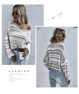Détail du pull en maille à rayures gris et blanc avec col rond et épaules tombantes