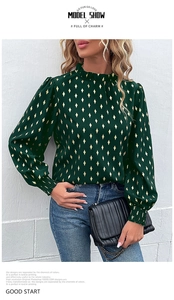 Close-up of dark green blouse with gold diamond pattern, ruffle neck and elastic cuffs