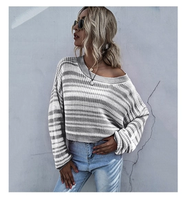 Gros plan du pull en maille rayé gris et blanc montrant la texture et les poignets côtelés