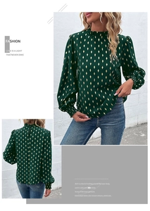 Detailed view of dark green high neck shirt with gold diamond pattern and lantern sleeves