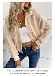 Dettaglio della giacca in pile beige con zip, colletto alto e polsini a costine