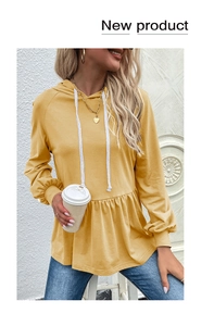 Dettaglio della felpa con cappuccio giallo zenzero con fondo a peplo e cordoncini