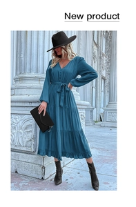 Detail of V-neck peacock blue long sleeve dress with waist tie and tiered skirt design