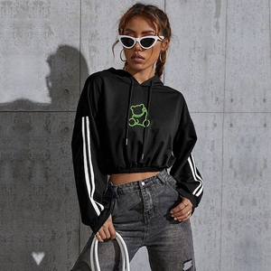 Detail of black cropped hoodie featuring neon green bear print and white sleeve stripes