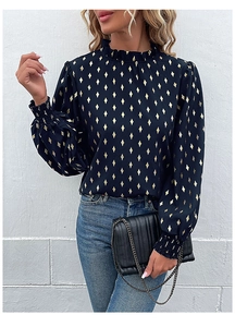 Close-up of women's black shirt with gold diamond pattern and ruffled stand collar