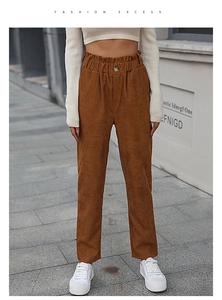 Detailed view of the ruffle elastic high waist and button on brown corduroy trousers