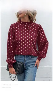 Close-up of wine red blouse with gold diamond sequins, ruffle neck and elastic cuffs