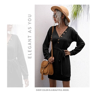 Détail du col en V avec boutons décoratifs sur une robe midi noire en maille gaufrée