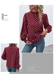 Detail of burgundy women shirt with gold geometric patterns and ruffled high neck