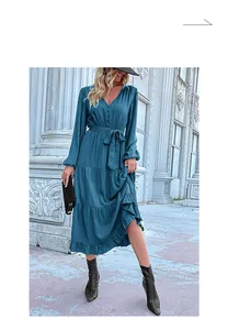 Detail of teal tiered dress with V-neckline, buttons, and delicate ruffle trim details