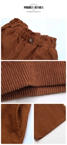 Detail view of brown corduroy pants showing elastic waist, texture, and hem stitching