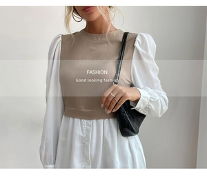 Détail d'une robe bicolore kaki avec manches bouffantes blanches et ourlet boutonné