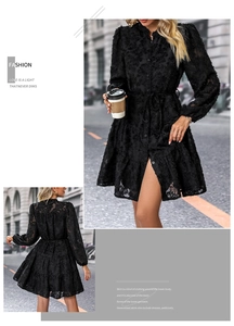 Detail of black long sleeve lace dress with floral textures and ruffled hemline
