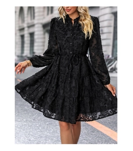 Close-up of black long sleeve dress with textured floral mesh fabric and tiered skirt details