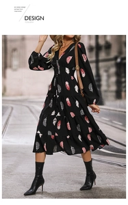 Détail de l'encolure en V et du boutonnage sur une robe noire à manches longues et plumes