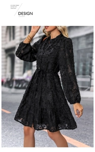 Detail of black tiered long sleeve dress with 3D floral texture and waist tie