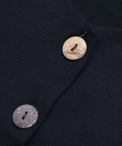 Dettaglio dei bottoni in legno naturale su una tuta sportiva in maglia nera